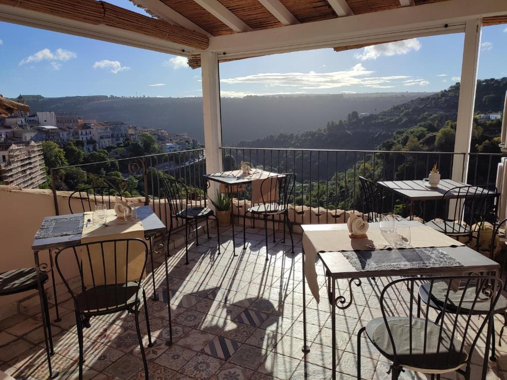 eine Terrasse mit Tischen und Stühlen auf dem Balkon in der Unterkunft Evoca in Ragusa