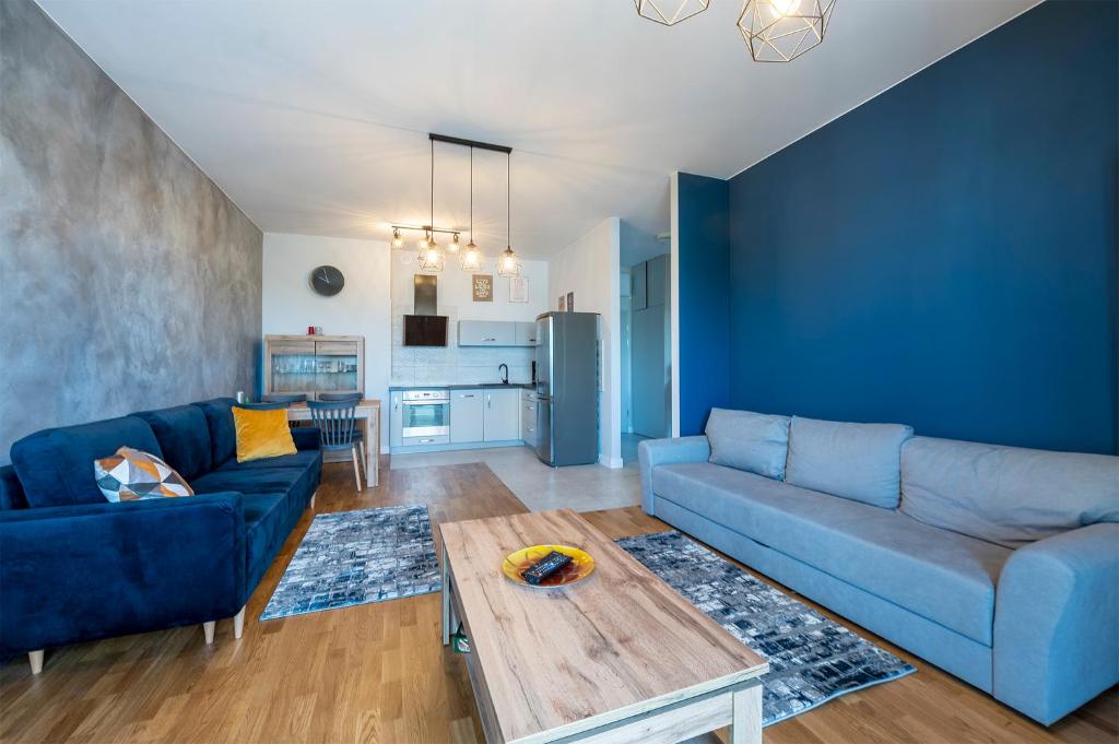 un soggiorno con divano blu e tavolo di Luxury in City -5- Free Parking a Łódź
