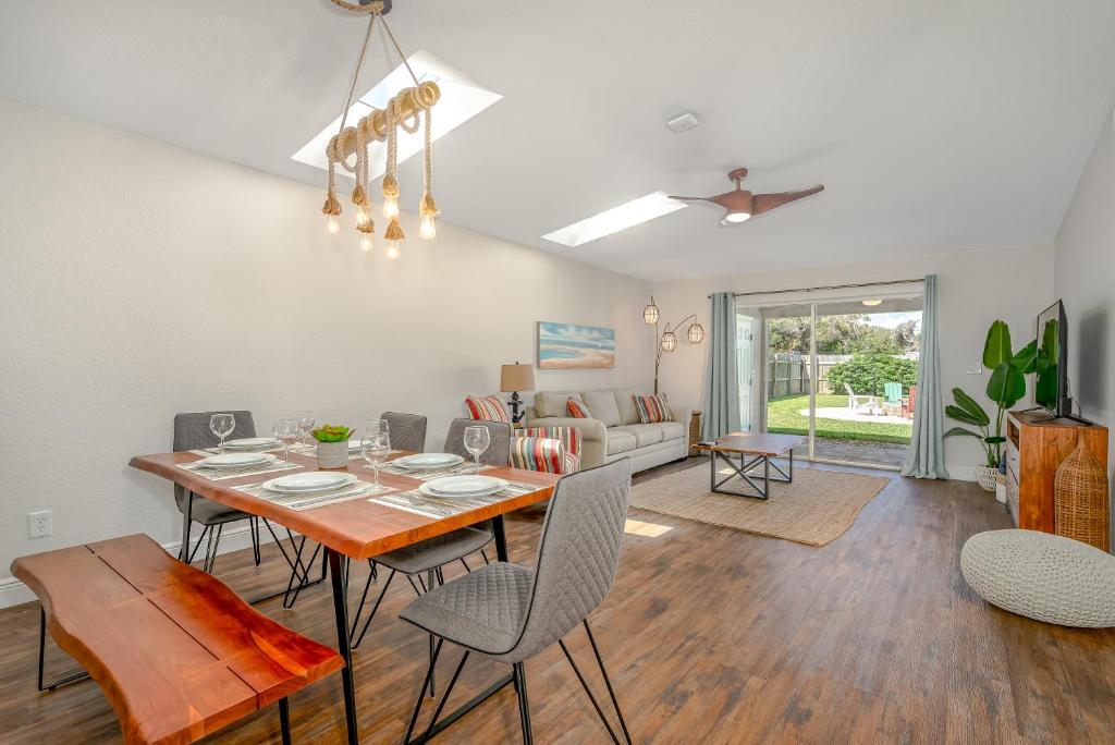 a dining room and living room with a table and chairs at Unique Balinese Home with Fire Pit and Private Fenced Yard! 30 Seconds to the Sand! in New Smyrna Beach
