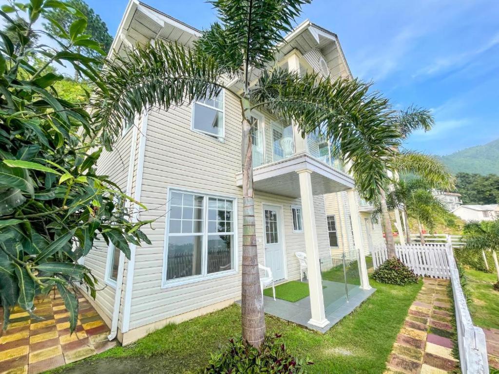 a house with a palm tree in front of it at Le Reve Valley - Canadian cottage 2 - 3BHK Luxury cottage,Bonfire,Barbeque,Gym,Kids play zone,Lake view in Bhīm Tāl