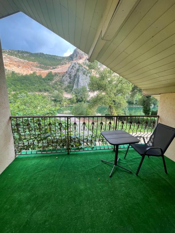 a table and a chair on a balcony with a view at Neretva View in Počitelj