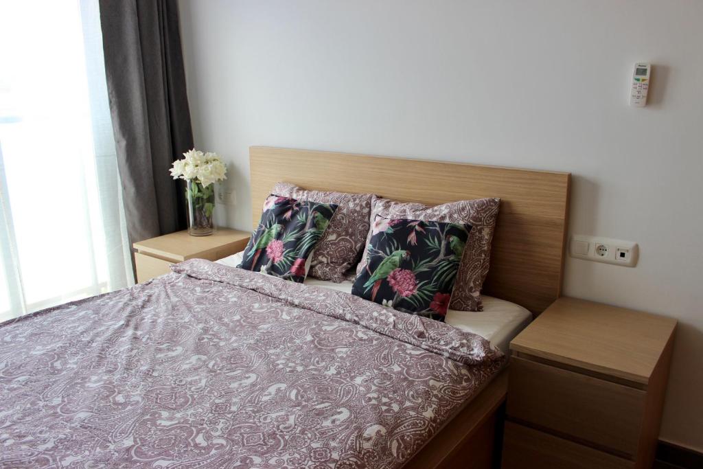 een slaapkamer met een bed met een paarse deken en kussens bij S215 Apartamento Las Dunas Oliva Nova in Oliva