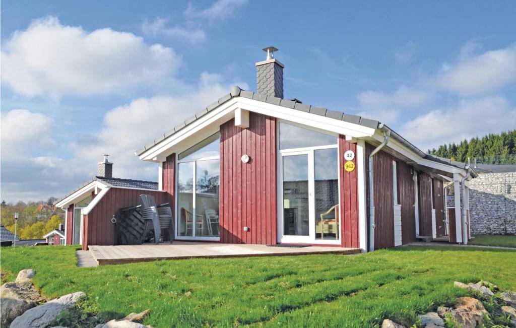 a red house with a large window on a lawn at St, Andreasberg, Haus 42 in Sankt Andreasberg