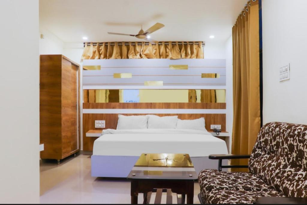 a hotel room with a bed and a couch at Hotel Menaka in Vijayawāda