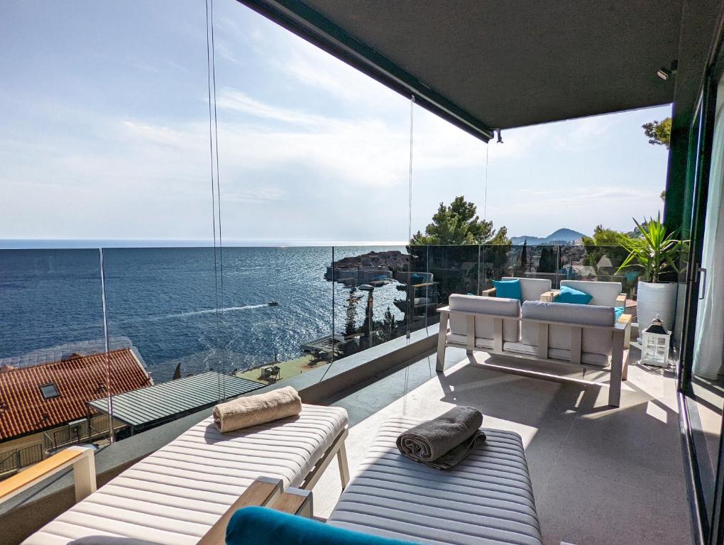 a balcony with chairs and a view of the ocean at Beyond Breathtaking Modern Residence Sir. Perfect in Dubrovnik