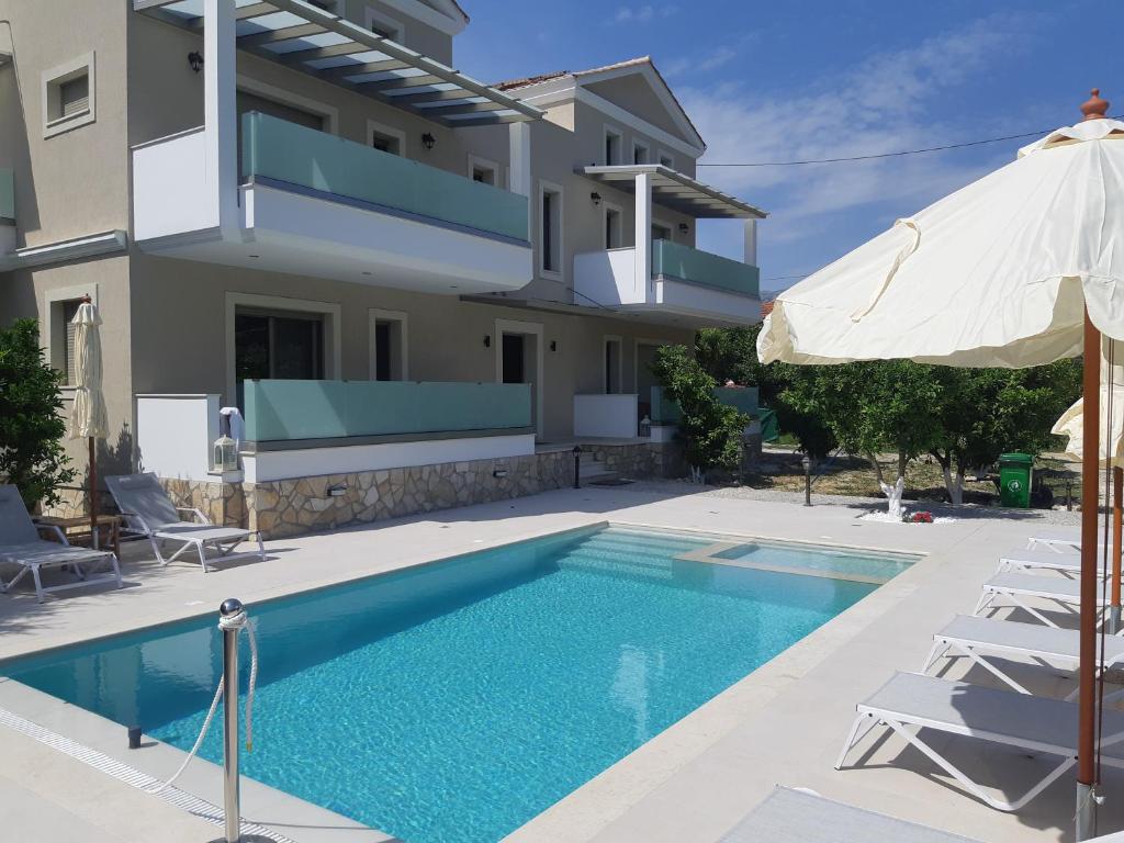 a villa with a swimming pool in front of a house at Kampos Apartment in Vasiliki
