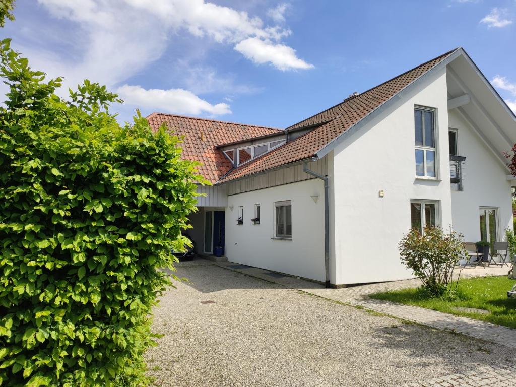 ein weißes Haus mit rotem Dach in der Unterkunft Ferienwohnung Hemer in Schrozberg