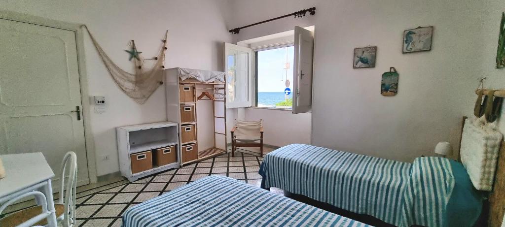 ein kleines Zimmer mit 2 Betten und einem Fenster in der Unterkunft Casa Cristina in Torre Canne