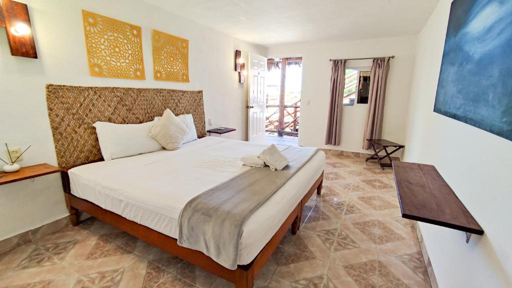a bedroom with a large bed in a room at Blatha Tropical Rooms Holbox in Holbox Island