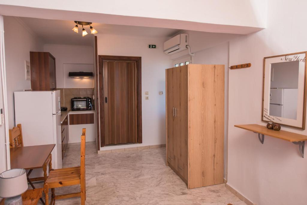 a kitchen with a table and a wooden door at Elena Studios in Athani