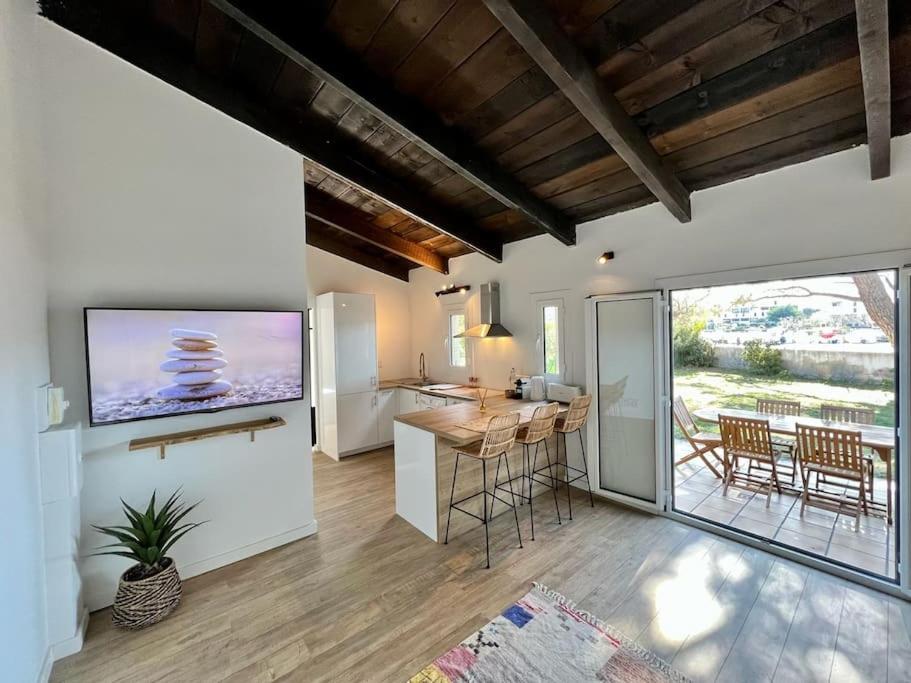 een keuken met een tafel en een tv aan de muur bij maison chaleureuse en plein coeur du centre ville in Saint-Florent