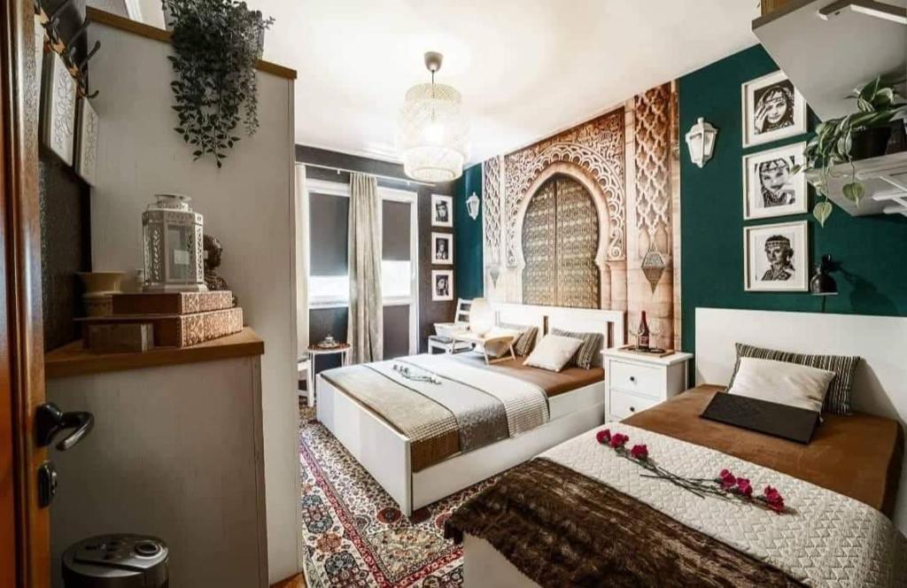 a bedroom with two beds and a green wall at Bohemian Elly room Varna in Varna City