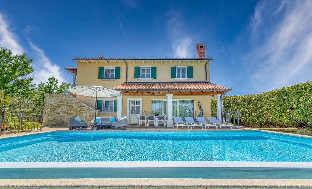 a villa with a swimming pool in front of a house at Villa Sana in Selina
