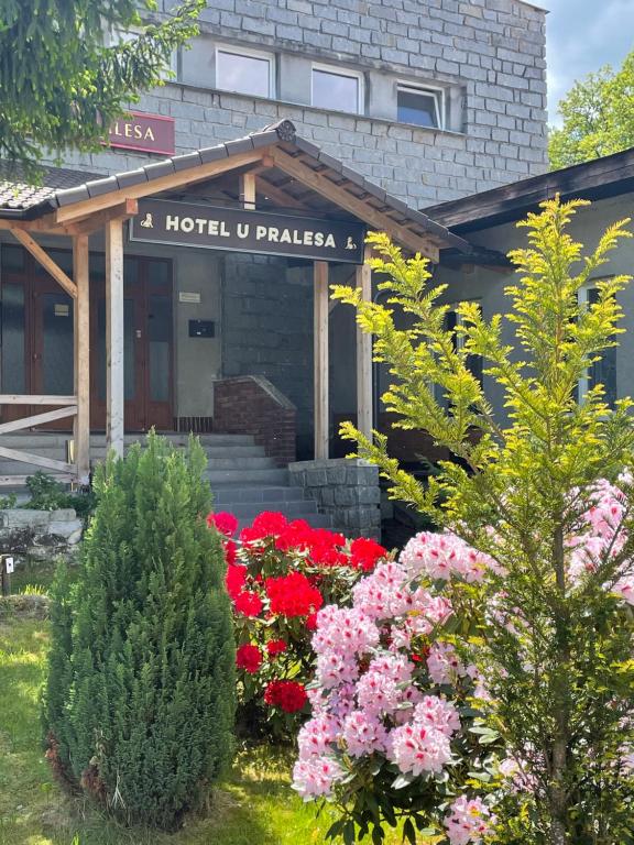 a hotel with flowers in front of a building at Apartmány IMLADRIS, Hotel u pralesa in Benešov nad Černou