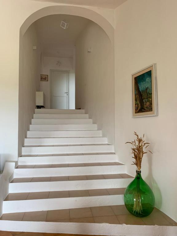 a stairway with a green vase sitting on a table at Casa Le Cicale in Porto Istana