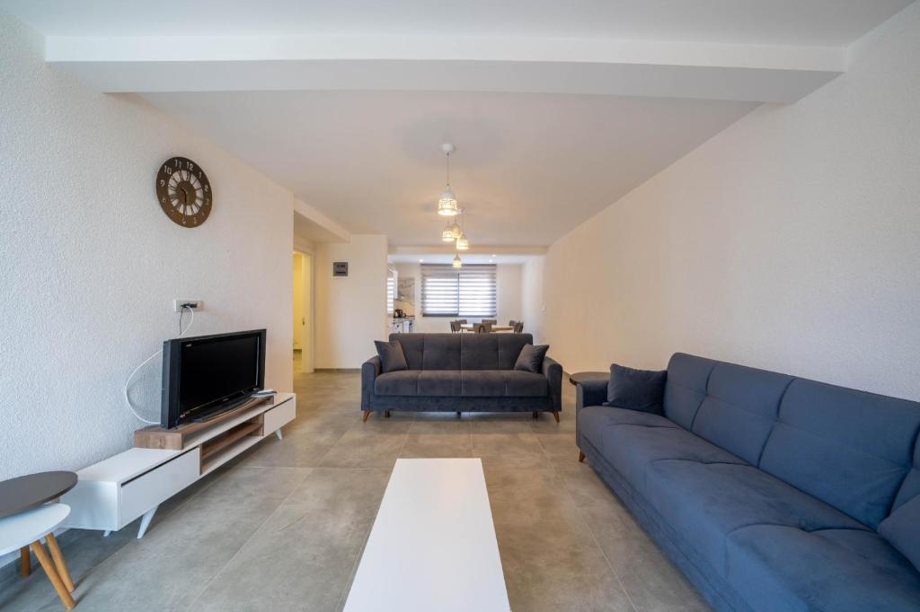 un soggiorno con un divano blu e una TV di Naz Liman Otel Bodrum a Bodrum City