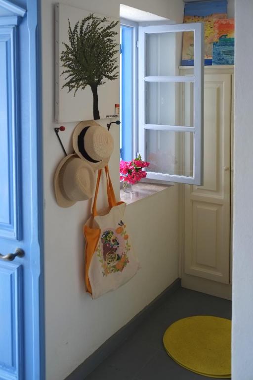 a hat hanging on a wall next to a window at Little Symi House in Symi