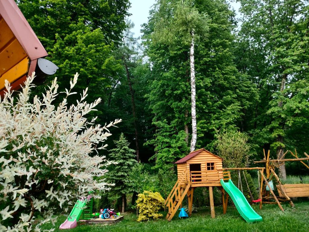 plac zabaw z domkiem na drzewie i huśtawką w obiekcie Domki i Pokoje u Borsa w mieście Lesko