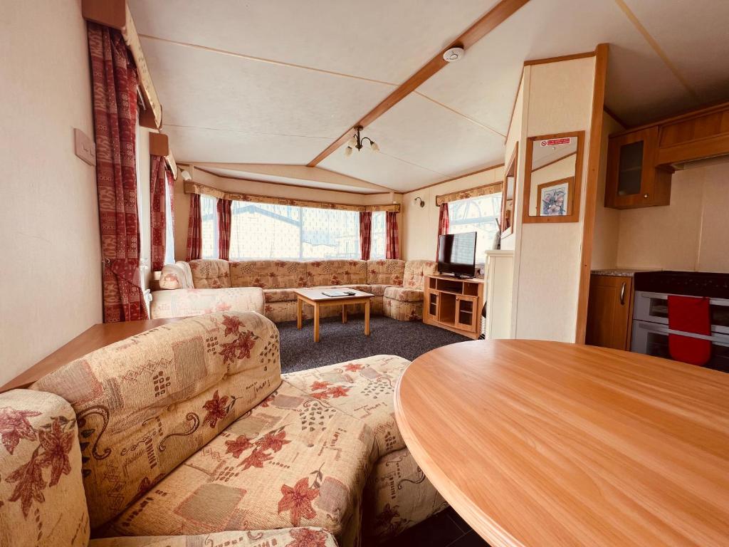 a living room with a table and a couch at Fantasy Island Caravan Hire- Located at Fantasy Island- Eastgate Caravan Park, Sea Lane, Ingoldmells in Ingoldmells