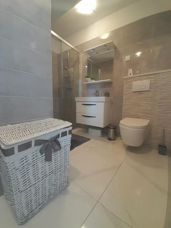 ein Badezimmer mit einem WC, einem Waschbecken und einem Spiegel in der Unterkunft Apartment Karlito in Omiš