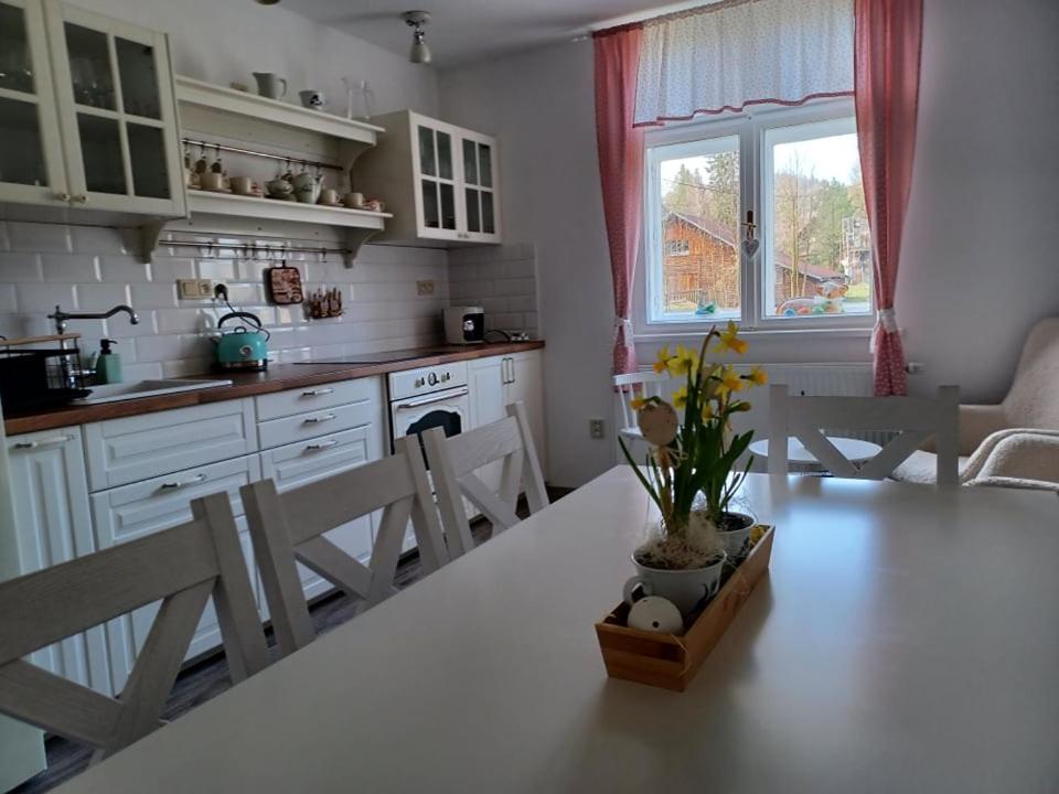 a kitchen with a white table and chairs and a window at CHalupa Relax in Dolní Lomná