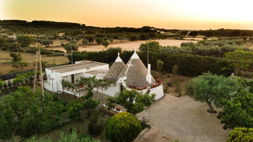 an aerial view of a white house with trees at Trulli Ulivi in Putignano