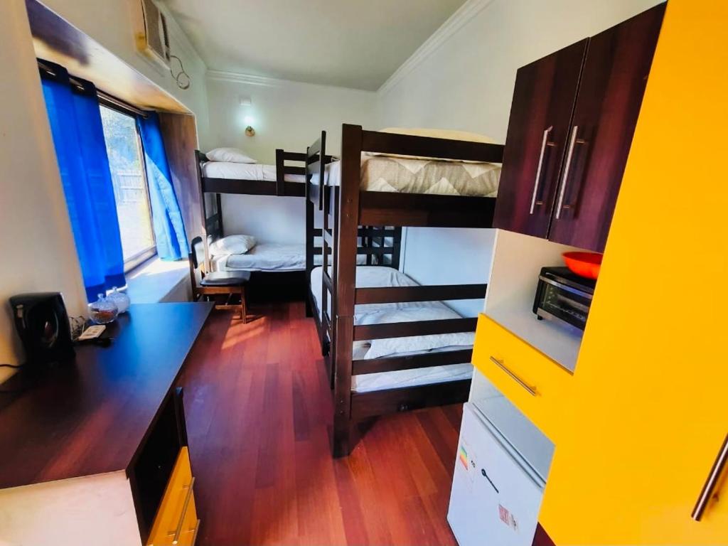 プコンにあるCabañas Habitainer 3の二段ベッド2台、デスクが備わる客室です。