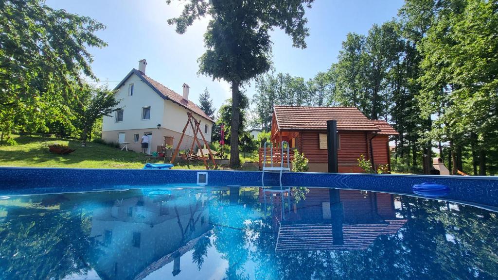 a swimming pool in front of a house and a house at Baberius in Babe