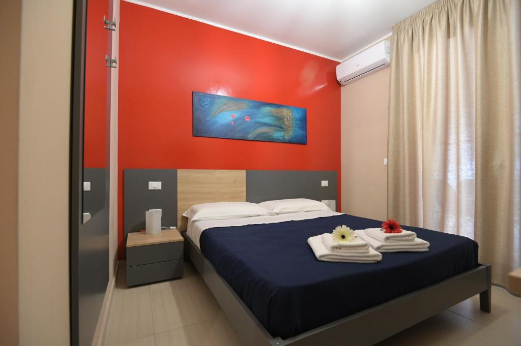 a bedroom with a bed and a red wall at CLC Home B&B in Cosenza