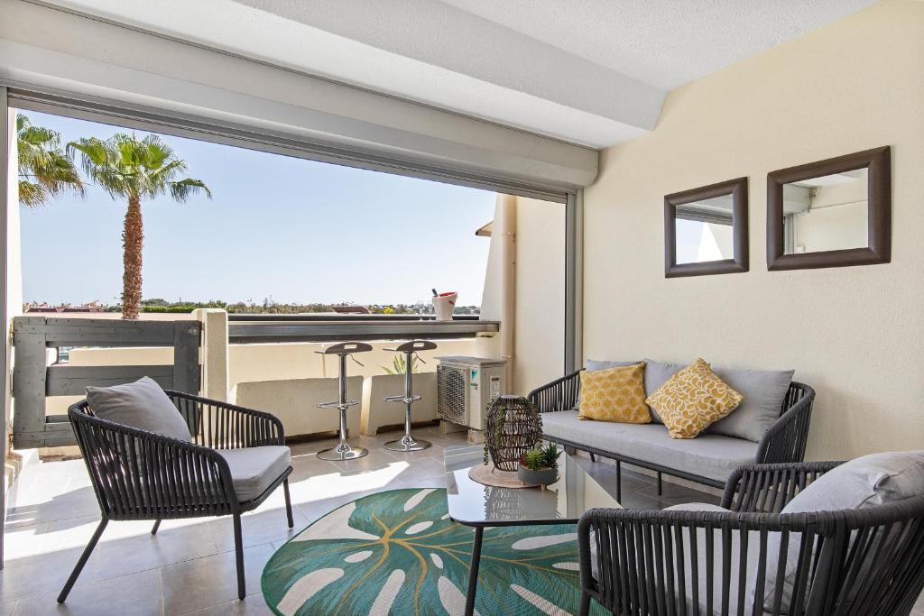 un salon avec un canapé, des chaises et une table dans l'établissement Sud coursive naturiste, au Cap d'Agde