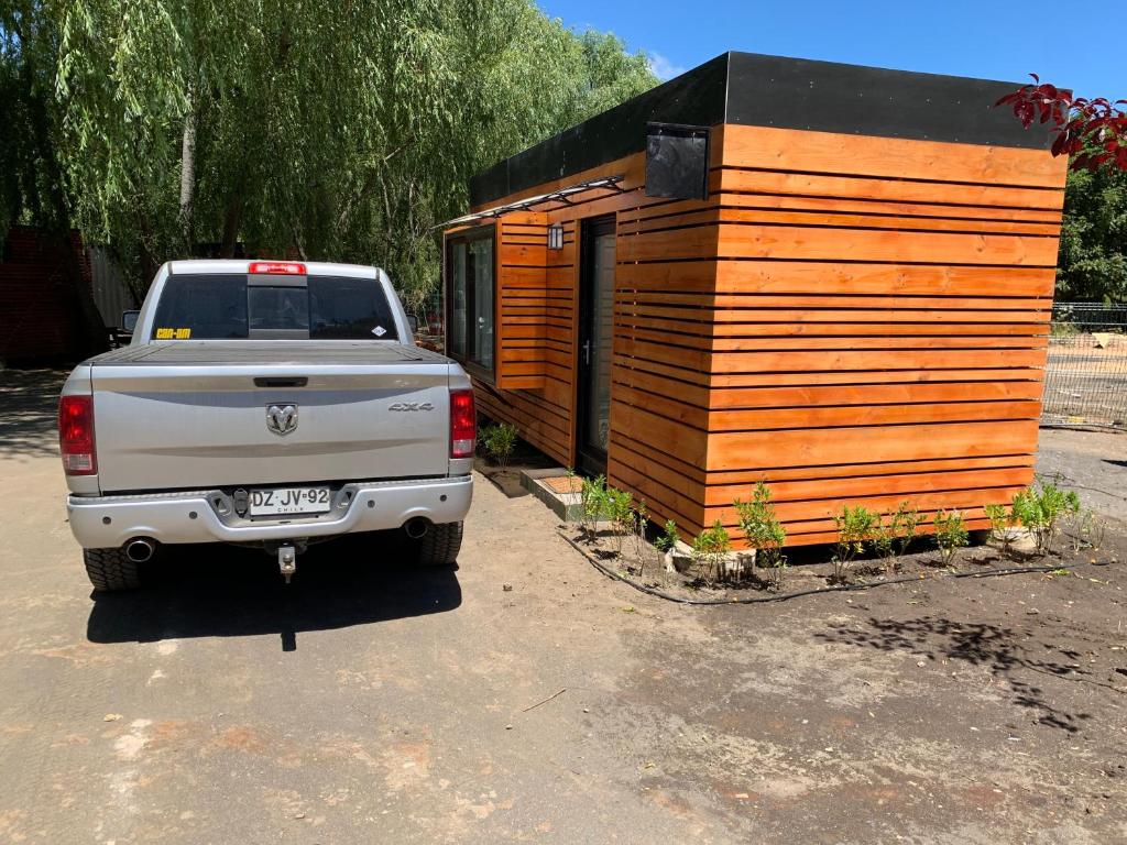 a white truck parked next to a tiny house at Cabañas Habitainer BordeRio 2 in Concepción