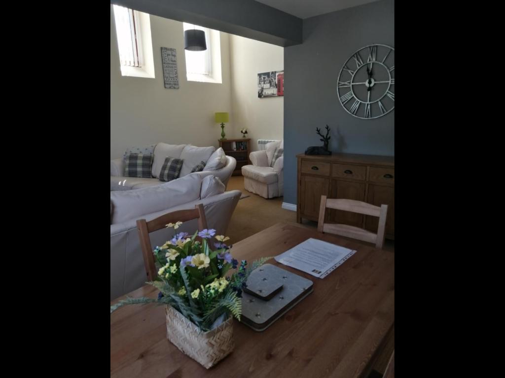 a living room with a white couch and a table with flowers at No4 Millhouse Flats in Inverlochy