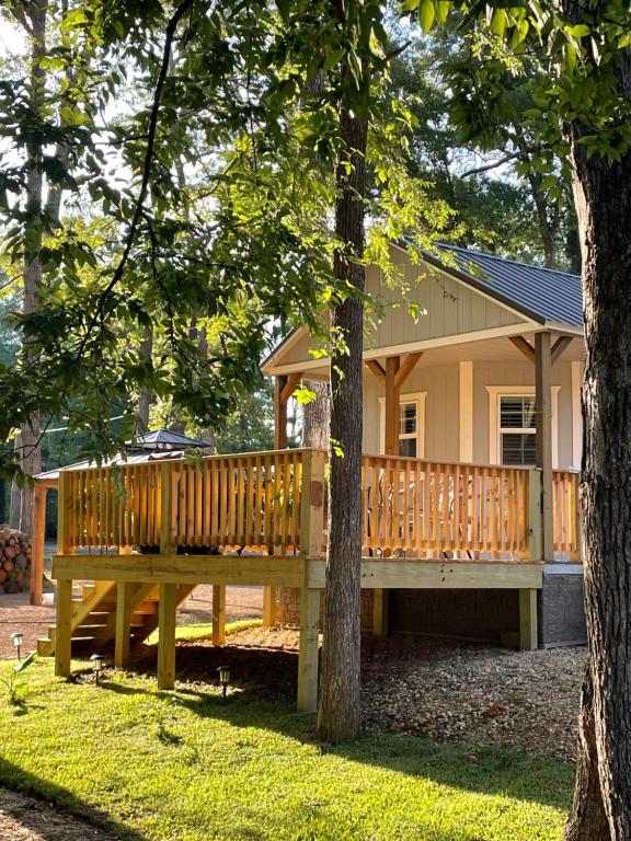 AvingerにあるCozy Cabin in Crestwood Subdivisionの庭に広い木製デッキがある家