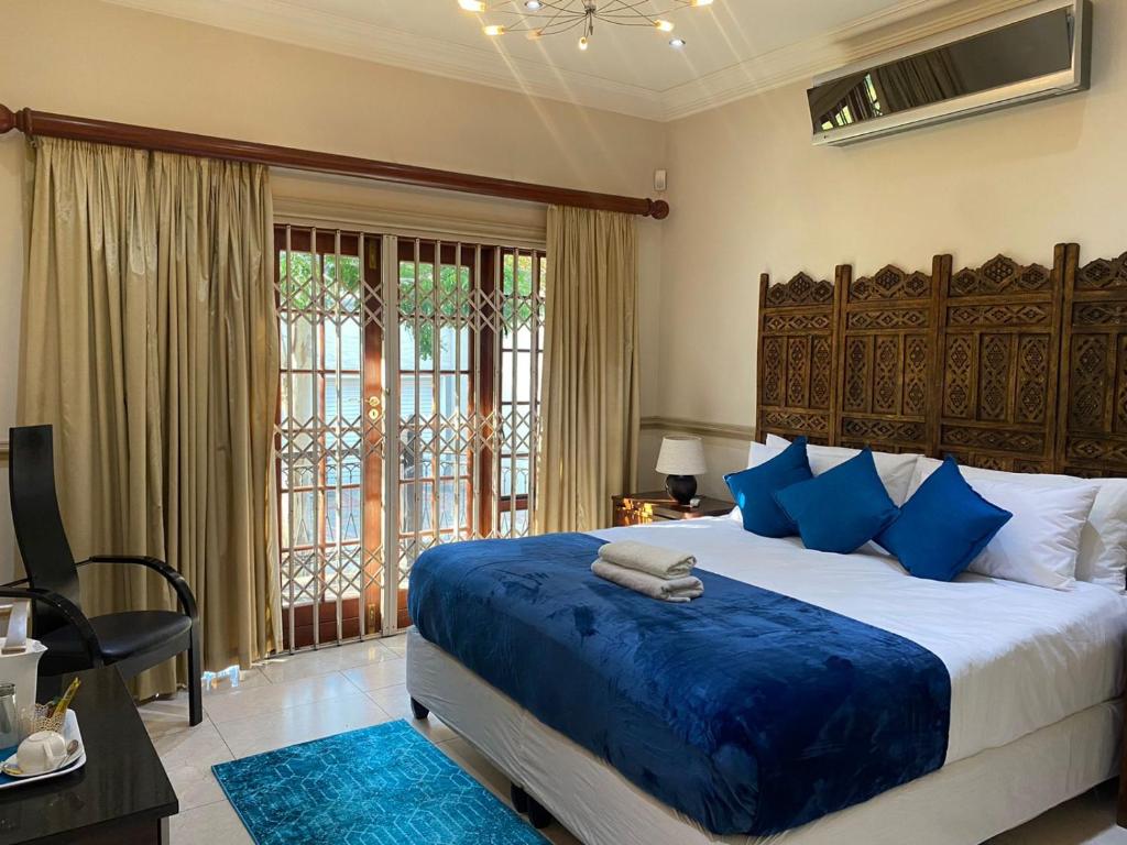 a bedroom with a large bed with blue pillows at The grand palm in Pretoria