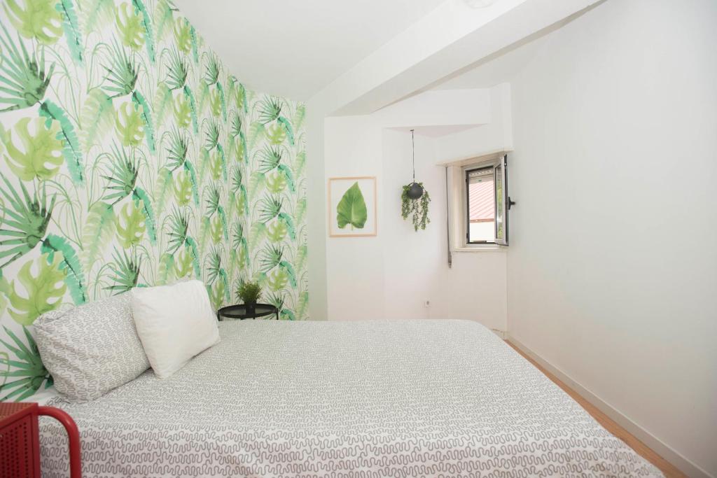 a bedroom with a bed and a floral wallpaper at Travel & Live Marques in Porto