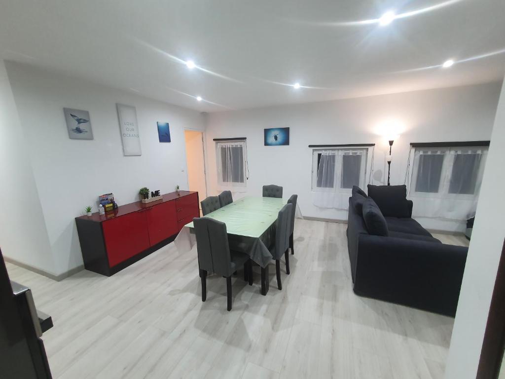 un salon avec une table et un canapé dans l'établissement Au coeur Normand Magnifique maison avec jacuzzi 25mn de la mer, à Audrieu