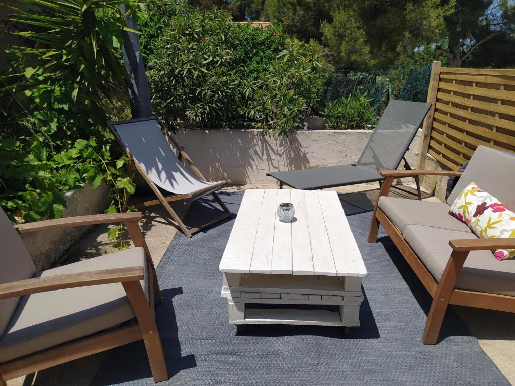 un grupo de sillas y una mesa de centro en un patio en Les Mondes - Appartement bas de maison en Ensuès-la-Redonne