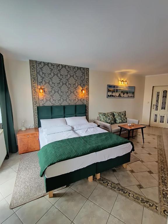 a bedroom with a large bed and a couch at Apartamenty Hexagon nr 32 in Grzybowo