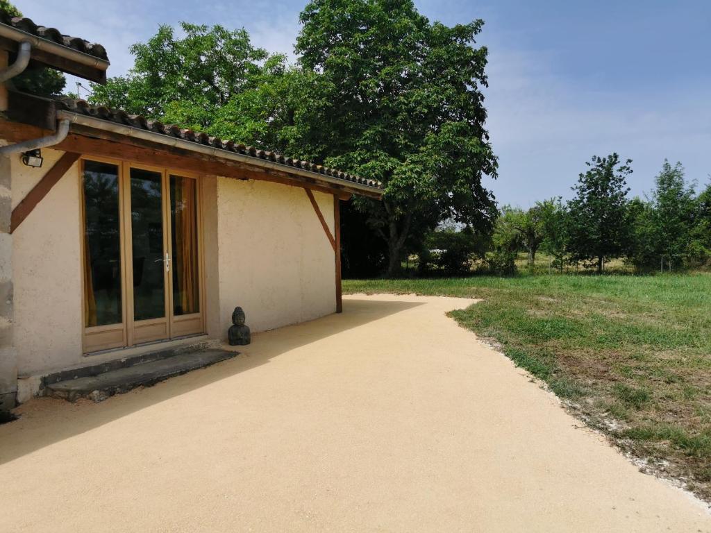 a building with a walkway next to a field at Les gîtes de la nouvelle vie in Agnac