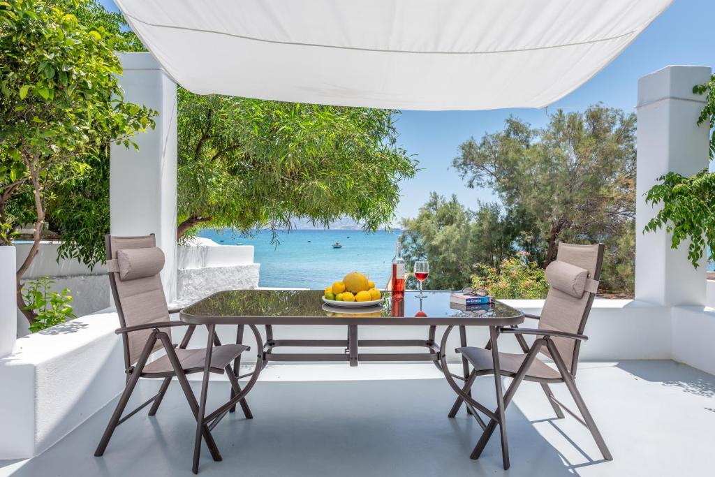 una mesa y sillas en un patio con vistas al océano en Ahinos en Pollonia