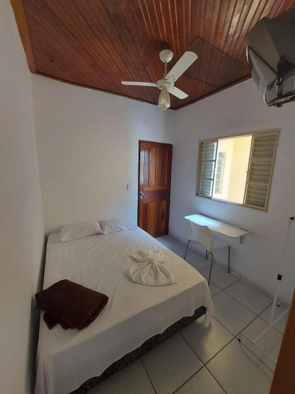 イタジュバにあるNovo Hotelのベッドと天井扇風機のある寝室