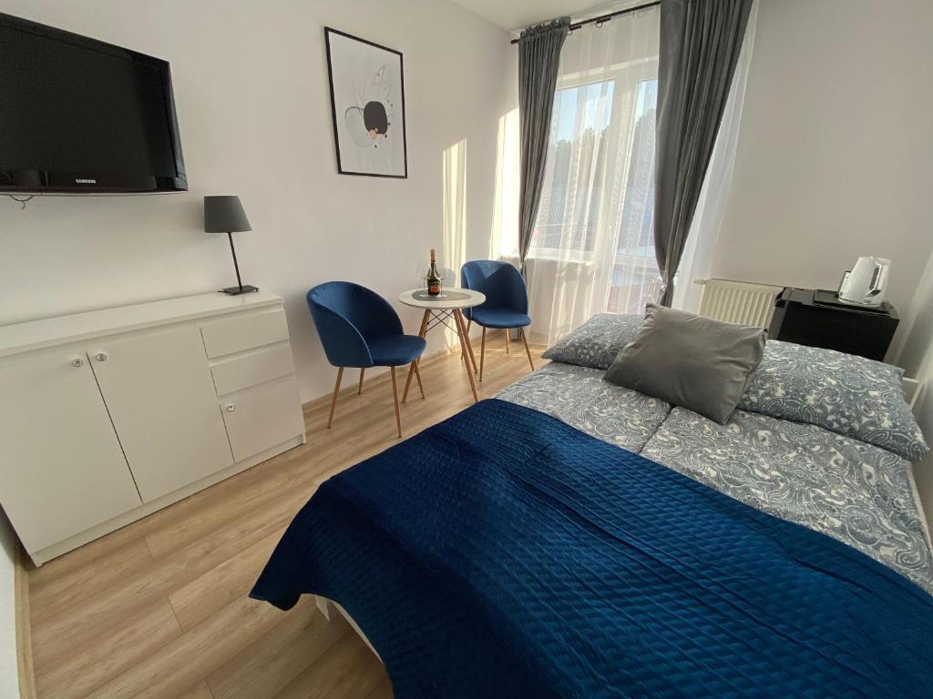 a bedroom with a bed and a table and chairs at Dom gościnny Jarek in Rowy