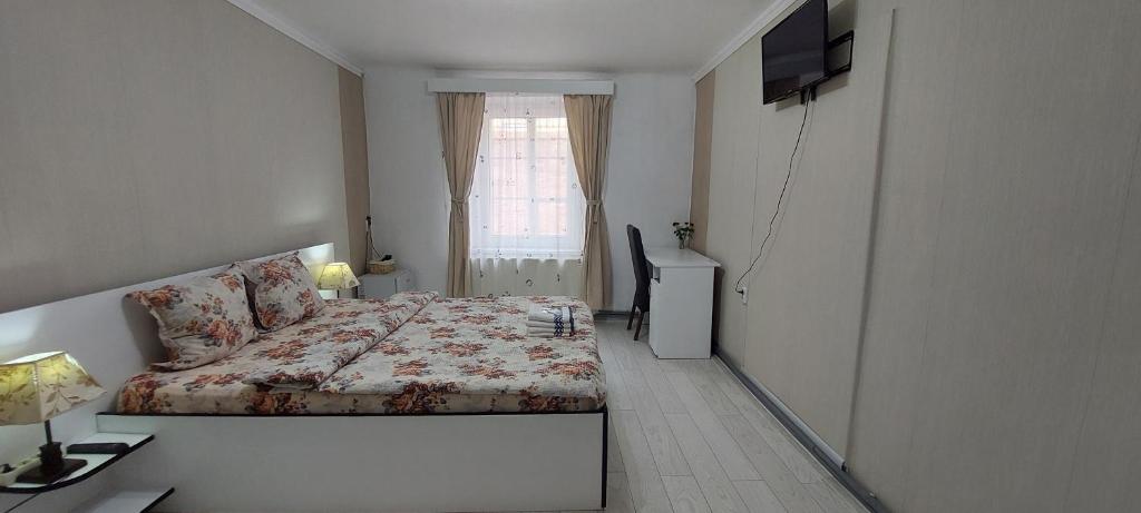 um pequeno quarto com uma cama e uma janela em Casa Merisor em Sibiu