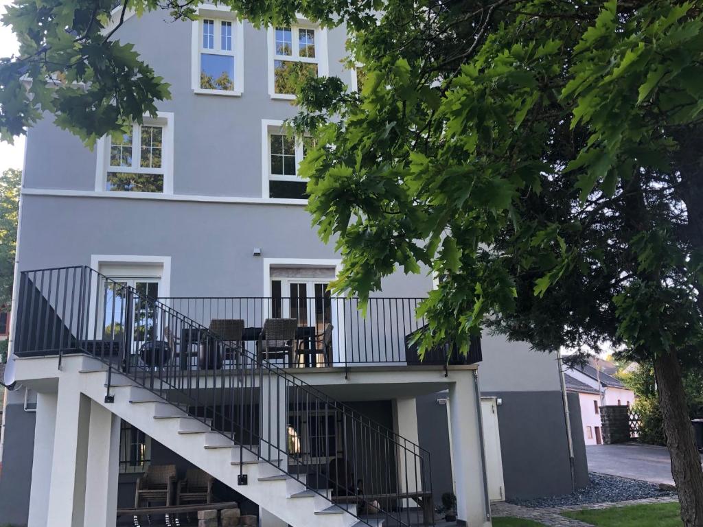 een wit gebouw met een trap ervoor bij Mein Eifel Ferienhaus Altes Pfarrhaus in Dahlem