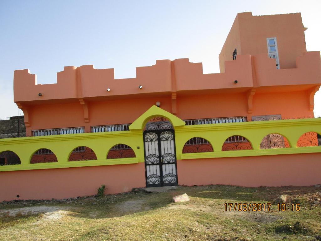 a building with a yellow and orange at Villa meublée climatisée in Ziguinchor