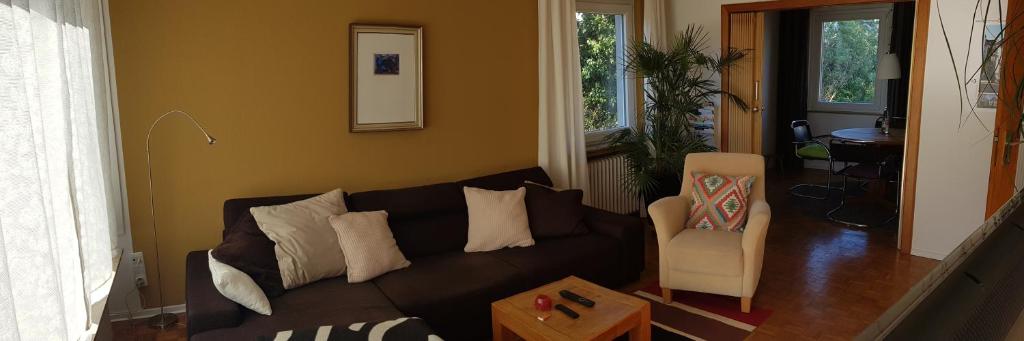 Stadtnahe Wohnung mit kl.Balkon und Parkplatz في أولدنبورغ: غرفة معيشة مع أريكة سوداء وكرسي