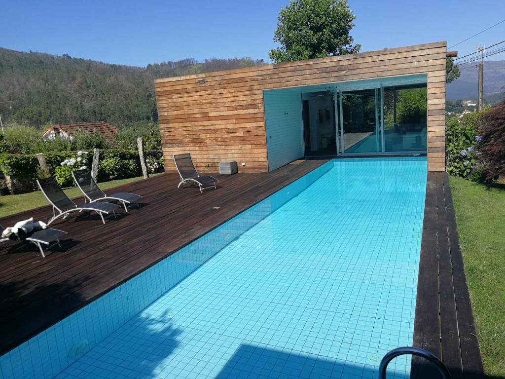 a swimming pool with chairs and a house at Espectacular villa en Mondariz, Casa Mirabal in Pontevedra