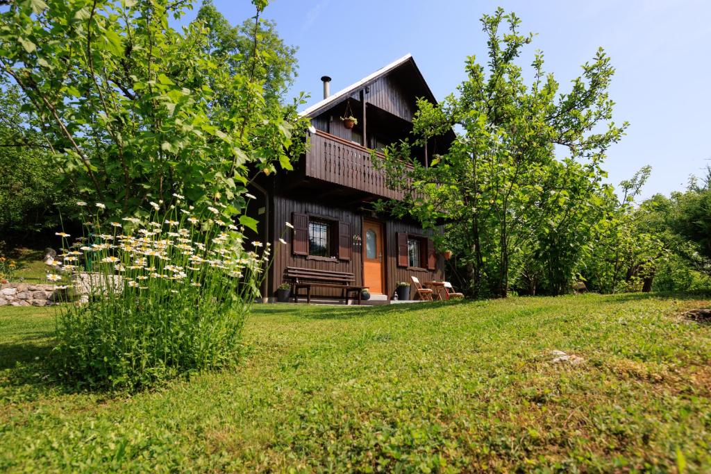 a house on a hill with a green yard at Počitniška hiša ErOs in Bohinj