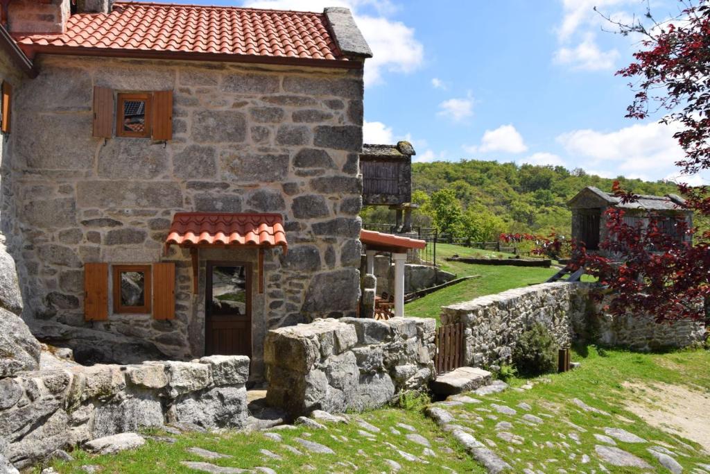 une ancienne maison en pierre avec un mur en pierre dans l'établissement O XARDÍN DA FRAGA, à San Salvador