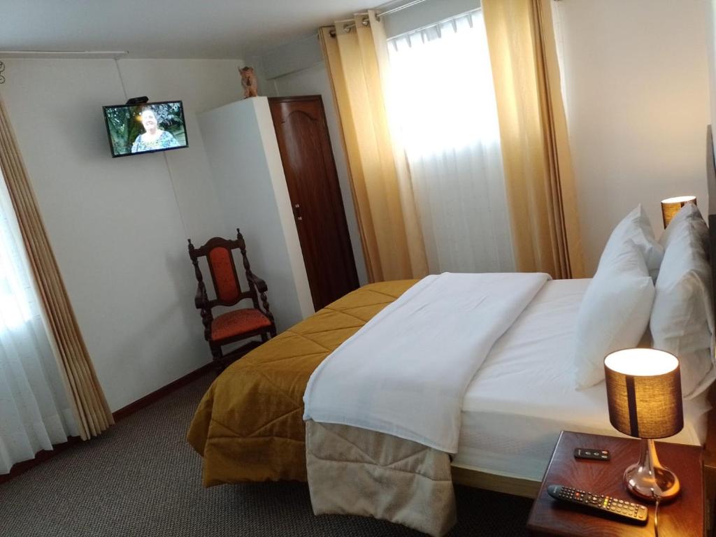 um quarto de hotel com uma cama e uma cadeira em Pukara House em Puno